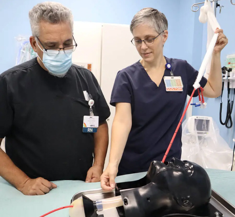 Medical professional performing a simulated emergency procedure using a SimKit training model in a clinical environment.